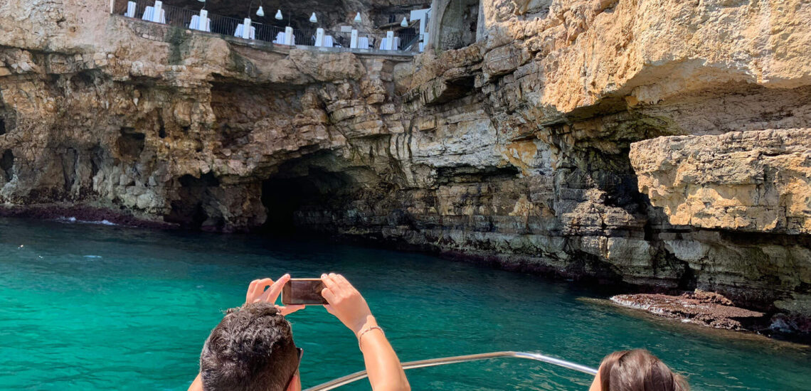 Turisti ammirano la Grotta Palazzese durante il tour in barca