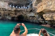 Turisti ammirano la Grotta Palazzese durante il tour in barca