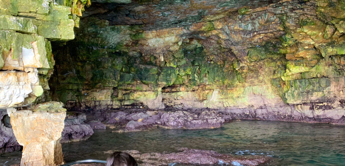 Turisti che fotografano le grotte dall'interno durante il nostro tour a Polignano a Mare